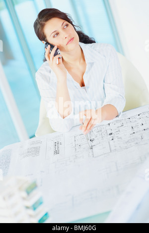 Woman looking at blueprints Stock Photo