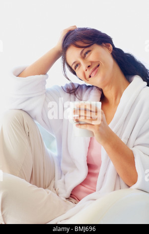 Woman in bathrobe drinking coffee Stock Photo