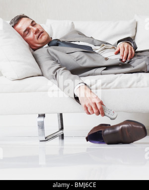 Businessman napping on couch Stock Photo