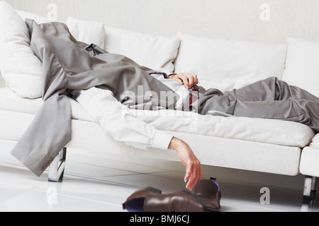 Businessman napping on couch Stock Photo