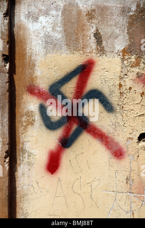 swastika graffiti painted on wall in city town Stock Photo
