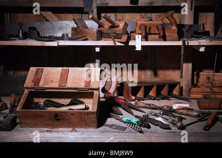 A nineteenth (XIX) century (1800s) work bench with saws, planers, hammers and many carpentry tools, Auckland, New Zealand Stock Photo