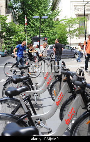 A row of [Bixi bikes] locked into their holders in the [public bike system] in Montreal. Stock Photo