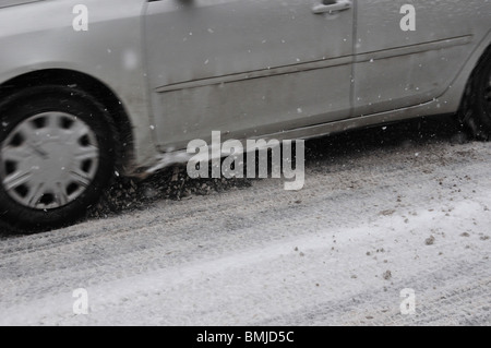 Tires of a car moving on a road winter Stock Photo