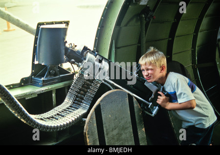 World War II military reenactor young boy plays around machine gun ammunition Stock Photo
