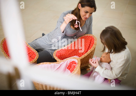 Pregnant woman playing with little girl Stock Photo