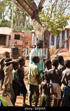 West Africa, Benin. Children gathered around man before Gelede Mask Dance. Stock Photo