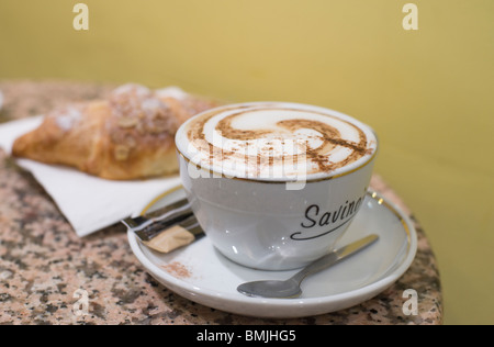 Café latte and an almond croissant at Savino's, a Cambridge café known for its Italian coffee and excellent baked goods. Stock Photo