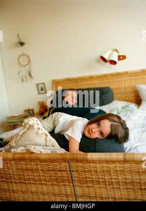 Mother and daughter lying in bed, Sweden. Stock Photo