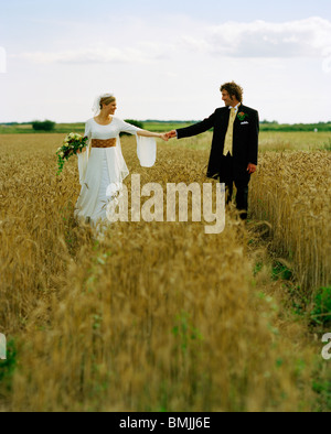 https://l450v.alamy.com/450v/bmjj6e/scandinavia-sweden-oland-bride-and-groom-walking-in-field-bmjj6e.jpg