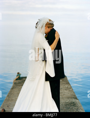 Scandinavia, Sweden, Oland, Groom and bride embracing on jetty Stock Photo