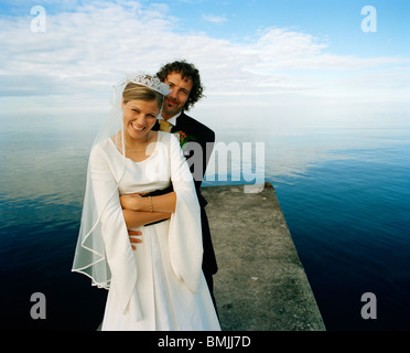 Scandinavia, Sweden, Oland, Groom and bride embracing on jetty, smiling, portrait Stock Photo