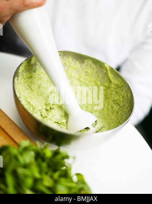 Scandinavia, Sweden, Stockholm, Person mixing basil with whisk, mid section, close-up