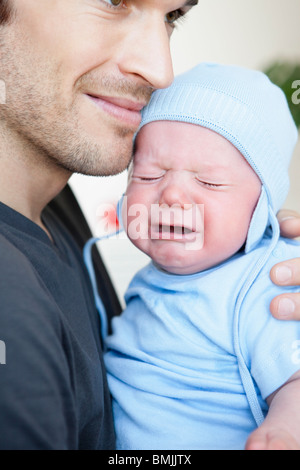Baby boy crying in fathers arm Stock Photo