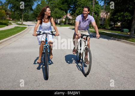 Two attractive adults, man and woman couple, cycling together. Stock Photo