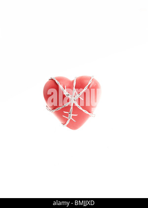 Barbed wire around a red heart. Stock Photo