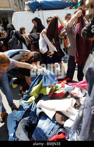 Women look and choose a stock of old used clothes in Porta Portese Rome Italy Stock Photo