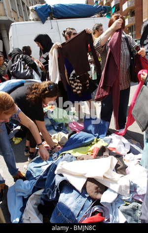 Women look and choose a stock of old used clothes in Porta Portese Rome Italy Stock Photo