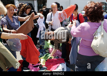 Women look and choose a stock of old used clothes in Porta Portese Rome Italy Stock Photo