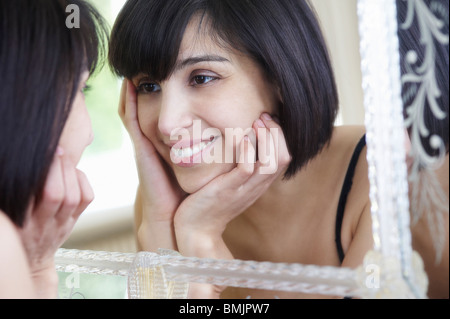 Woman looking in the mirror Stock Photo