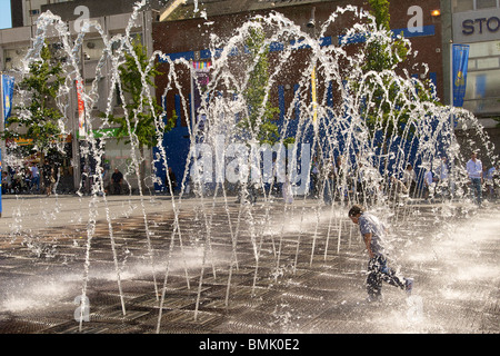 The fountain in Williamson Square in Liverpool with boy running through it. Stock Photo