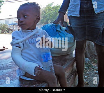 A young girl, survivor of the earthquake in Haiti, waits for medical attention n Port au Prince Stock Photo