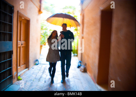 Couple with motion blur walking together with an umbrella under the rain in Rome Italy Stock Photo