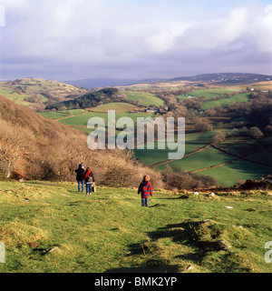 A young family walking down the hill in winter from a visit to Carreg Cennan Castle, Trapp, Wales, UK  KATHY DEWITT Stock Photo