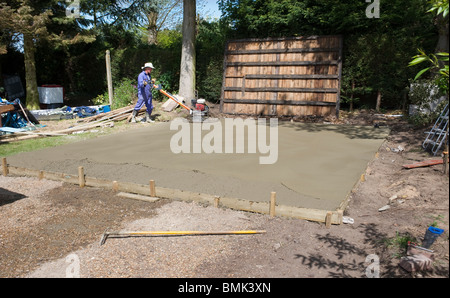 man leveling concrete base with power float Stock Photo