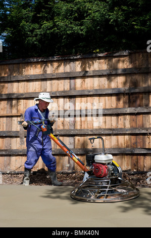 man levelling concrete base with power float Stock Photo