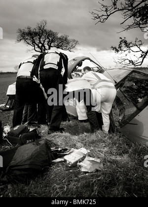 police and air ambulance paramedics work together to pull injured patient from car Stock Photo