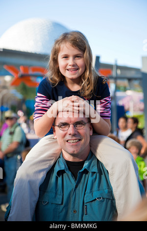 Young girl sitting on her father's shoulders at Walt Disney's Epcot Center in Orlando Kissimmee Florida Stock Photo