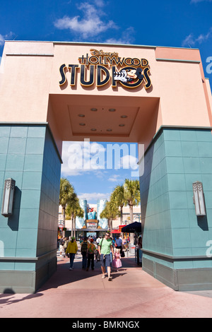 Park visitors walk under Disney's Hollywood Studios sign above walkway at Hollywood Studios theme park Stock Photo