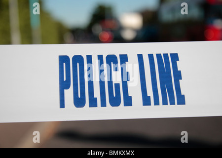 Police Line (Do Not Cross) tape from the United Kingdom (UK) across a road in West London. Stock Photo