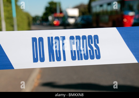 Police Line (Do Not Cross) tape from the United Kingdom (UK) across a road in West London. Stock Photo