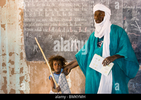 Mali. Tuareg teacher and girl in front of a blackboard at a primary school Stock Photo