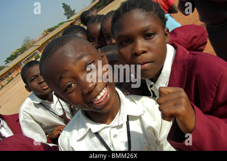 Nigeria, Jos, Sweating and smiling boy, a girl with a purple pullover standing at his side. Stock Photo