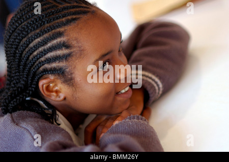 Nigeria, Jos, Portrait of a smiling schoolgirl with traditional plaits of Africa. Stock Photo