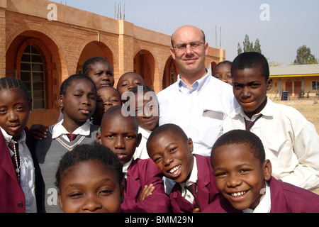 Nigeria, Jos, French director of the school and his students in the schoolyard. Stock Photo