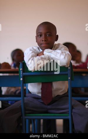 Portrait of a shoolboy sitting on a green chair with bluye bars Stock Photo