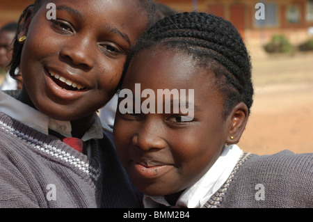Portrait of schoolgirls in their purple uniform, smiling and laughing, embracing each other Stock Photo