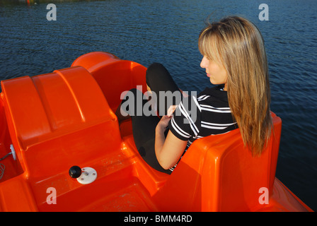 smiling blonde young woman on an orange boat Stock Photo