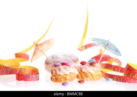 Two friedcakes with candies and ribbon on white background Stock Photo