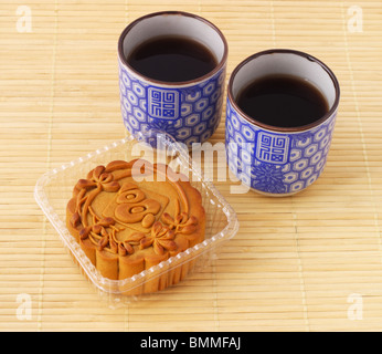 Chinese mid autumn festival moon cake and tea on bamboo mat Stock Photo