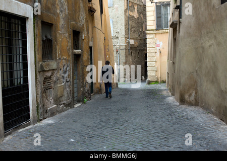 A man walking down a street in Rome Stock Photo