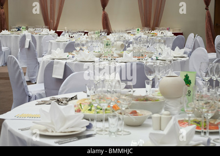 Wedding white reception place ready for guests. Elegant banquet tables prepared for a conference or a party. Stock Photo