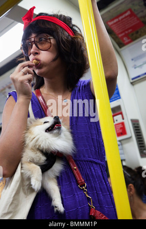 Woman carrying a dog in sling Stock Photo