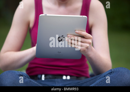 A woman uses a Ipad in the garden Stock Photo