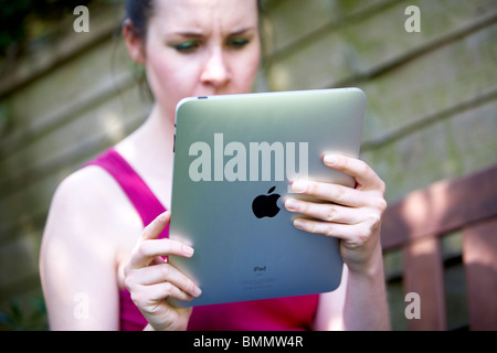 A woman uses a Ipad in the garden Stock Photo