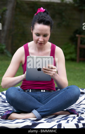 A woman uses a Ipad in the garden Stock Photo